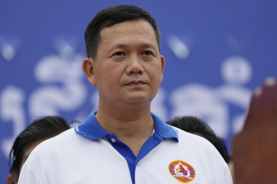 Hun Manet, right, a son of Cambodia Prime Minister Hun Sen, stands before he leads a procession to mark the end of an election campaign of Cambodian People's Party, in Phnom Penh, Cambodia, Friday, July 21, 2023. Hun Sen says he is ready to hand the premiership to his oldest son, Hun Manet, who heads the country’s army. (AP Photo/Heng Sinith)