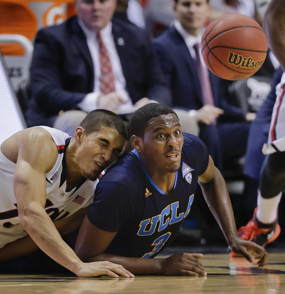 Arizona's Nick Johnson, left, and UCLA's Jordan Adams dive for a loose ball in the second half during the championship game of the NCAA Pac-12 conference college basketball tournament, Saturday, March 15, 2014, in Las Vegas. UCLA won 75-71. (AP Photo/Julie Jacobson)