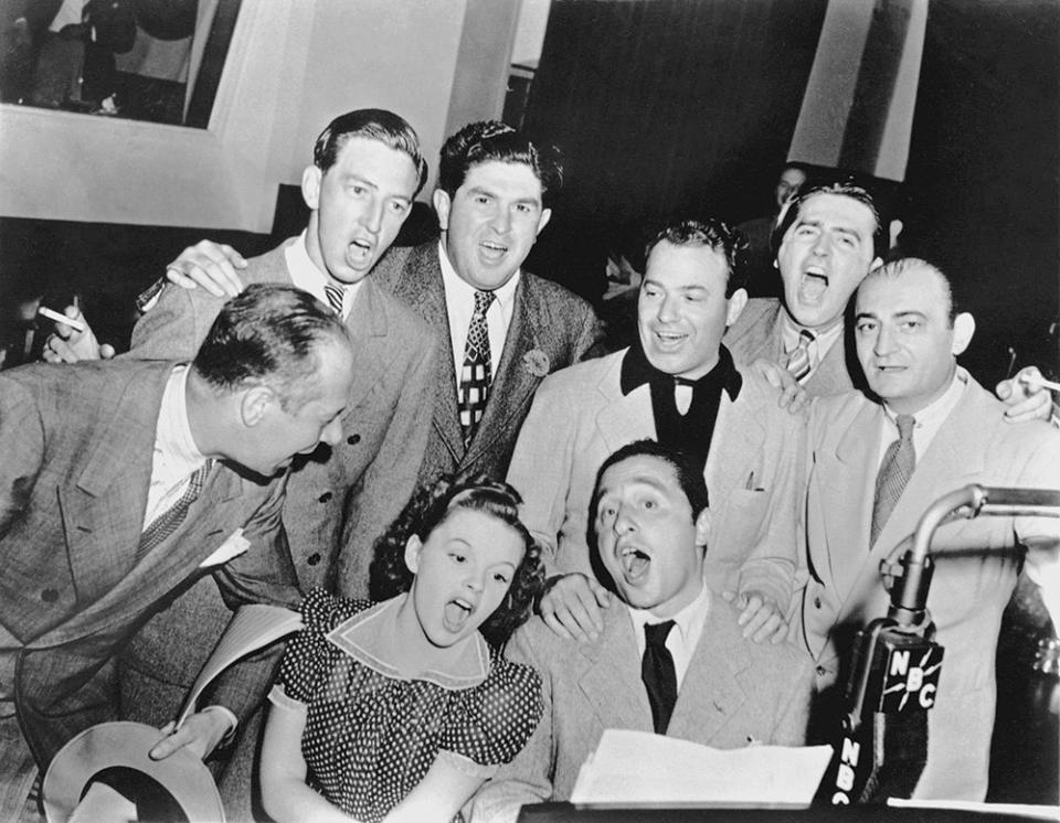 Bert Lahr, Ray Bolger, L.K. Sidney, Yip Harburg, Meredith Wilson and Harry Link surround Judy Garland and Harold Arlen in 1939