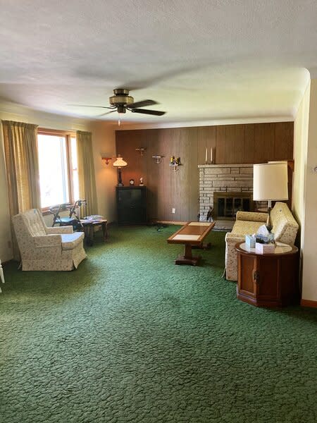 The living room, with its off-centered fireplace and general outdated appearance, before Bloom and her family took it to task.