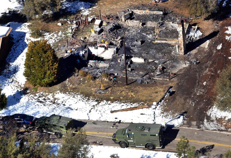 FILE - This Wednesday, Feb. 13, 2013 file photo this aerial photo, law enforcement authorities investigate the burnt-out cabin where accused quadruple-murder suspect Christopher Dorner died after barricading himself inside, during a stand-off with police in the Angeles Oaks area of Big Bear, Calif. Eight Los Angeles police officers who mistakenly riddled a pickup truck with bullets during a manhunt for cop-turned-killer Christopher Dorner last year will be allowed to return to the field after they get additional training, Police Chief Charlie Beck said. (AP Photo/The Sun, John Valenzuela, File)