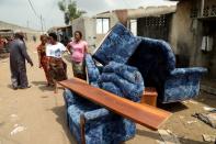 People stand next to their belonging as they prepare to leave their houses at Adjoufouin in the area around Felix Houphouet Boigny airport in Abidjan