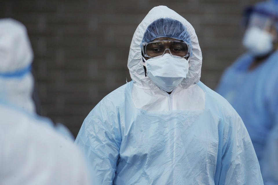 A medical worker wearing personal protective equipment pauses after wheeling a body to a refrigerated trailer serving as a makeshift morgue at Wyckoff Heights Medical Center, Monday, April 6, 2020, in the Brooklyn borough of New York. The new coronavirus causes mild or moderate symptoms for most people, but for some, especially older adults and people with existing health problems, it can cause more severe illness or death. (AP Photo/John Minchillo)