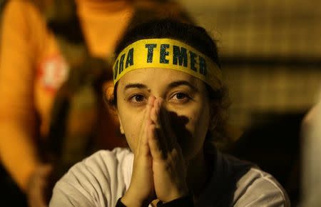 A woman attends a protest against the conviction on corruption charges of former president Luiz Inacio Lula da Silva, in Rio de Janeiro, Brazil July 20, 2017. The sign reads, "Out Temer". REUTERS/Pilar Olivares