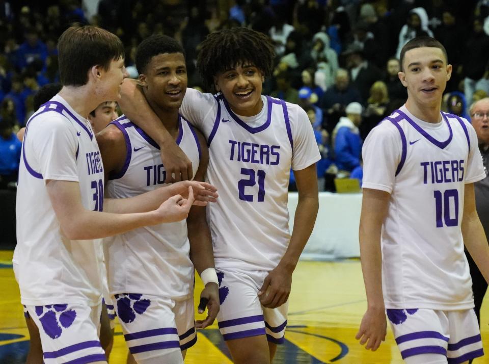 Pickerington Central’s Devin Royal (21) embraces Sonny Styles as they walk off the court with Gavin Headings and Andrew Hedgepeth (10) following a 59-42 win over Gahanna in a Division I regional final March 12 at Ohio Dominican.