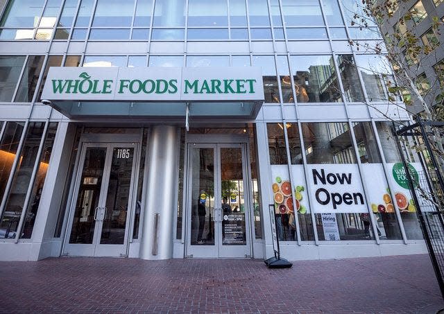 Whole Foods' flagship store in San Francisco shortly before it opened in March 2022. The store's entrance and a "Now Open" sign are visible from the street.