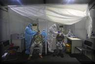 Indian health volunteers take swab samples as part of the India-Israel Non-Invasive Raid COVID-19 test study camp, at a government hospital in New Delhi, India, Friday, July 31, 2020. A team of Israeli scientists are in the country to carry out the final stages of testing of advanced technologies for real time rapid diagnosis of the coronavirus. (AP Photo/Manish Swarup)