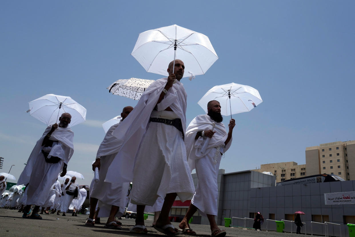 Muslim pilgrims walk, holding their umbrellas at the Mina tent camp in Mecca