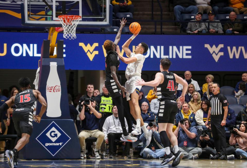 Jan 31, 2024; Morgantown, West Virginia, USA; West Virginia Mountaineers center Jesse Edwards (7) shoots against Cincinnati Bearcats forward Aziz Bandaogo (55) during the first half at WVU Coliseum.