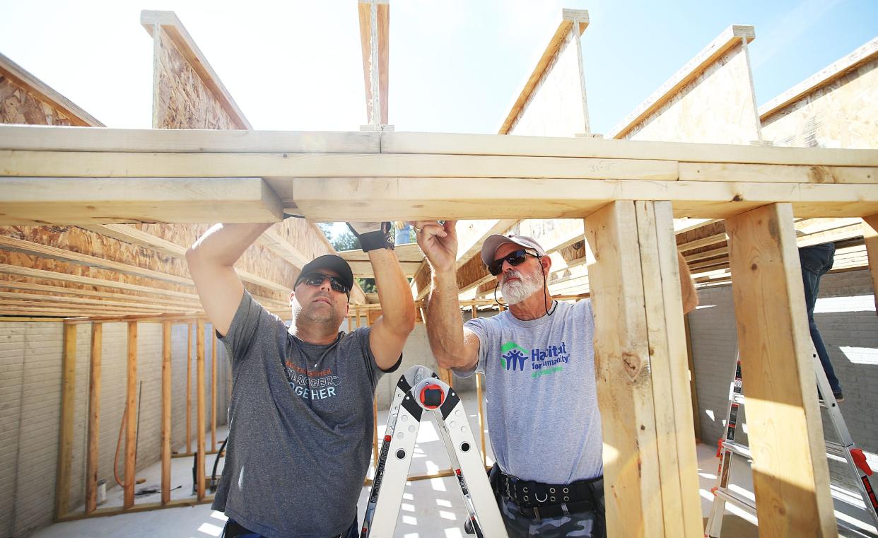 Curt Samson gets help from volunteer Justin Witek with First Interstate. The duo was helping build homes for Habitat for Humanity along Wilmoth Street Wednesday, Sept. 13 in Ames.