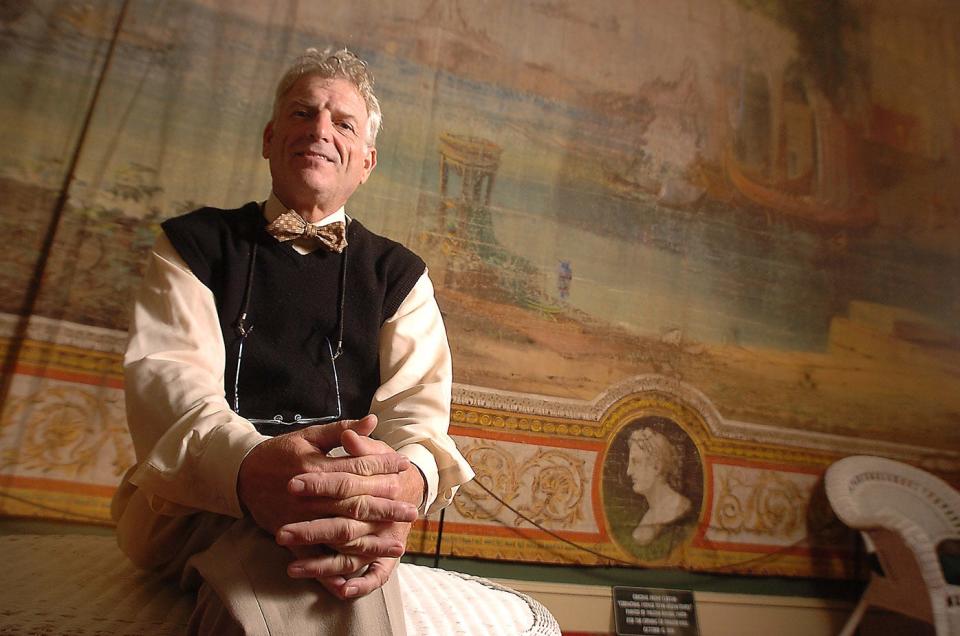 Tony Rivenbark sits in front of the original curtains at Thalian Hall. Rivenbark, who died in July of 2022 at age 74, had been the executive director of Thalian Hall since 1979.