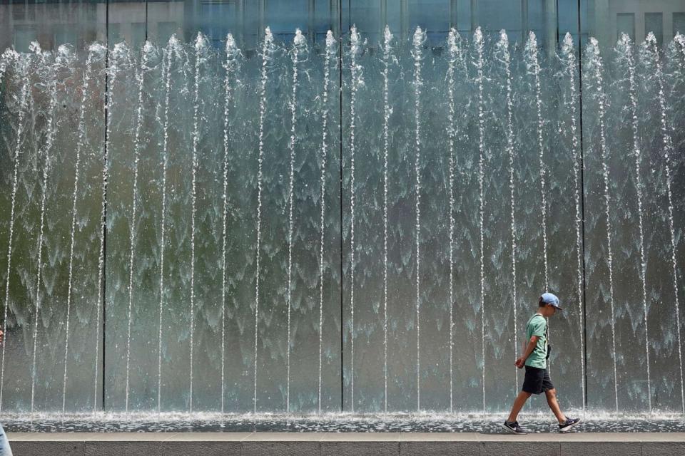 PHOTO: A boy walks on the edge of a fountain in Milan, Italy, July 19, 2023. (Luca Bruno/AP)