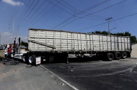 The wreckage of a tractor-trailer set ablaze by members of a drug cartel is seen blocking a road in Guadalajara May 1, 2015.REUTERS/Alejandro Acosta/File Photo