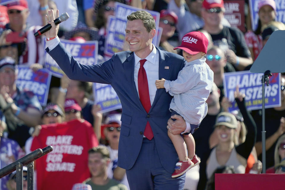 FILE - Republican U.S. Sen. candidate Blake Masters holds his son Rex, 2, as he speaks at a rally, Sunday, Oct. 9, 2022, in Mesa, Ariz. Masters, the Republican who ran for the U.S. Senate in Arizona and lost, demanded that the county recount the entire election because counted and uncounted ballots from two of its 223 voting locations were mixed together. Maricopa County election officials said the problem was caught, the batches re-run and no ballot was counted twice or not at all because of systems in place to catch that type of issue. (AP Photo/Matt York, File)