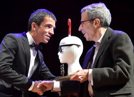 Luis Pallares Aniorte, of Spain, accepts the Ig Nobel prize for Obstetrics, for his group study showing that a developing fetus responds more strongly to music that is played electromechanically inside the mother's vagina than to music played electromechanically on the mother's belly, during the 27th First Annual Ig Nobel Prize Ceremony at Harvard University in Cambridge, Massachusetts, U.S. September 14, 2017. REUTERS/Gretchen Ertl