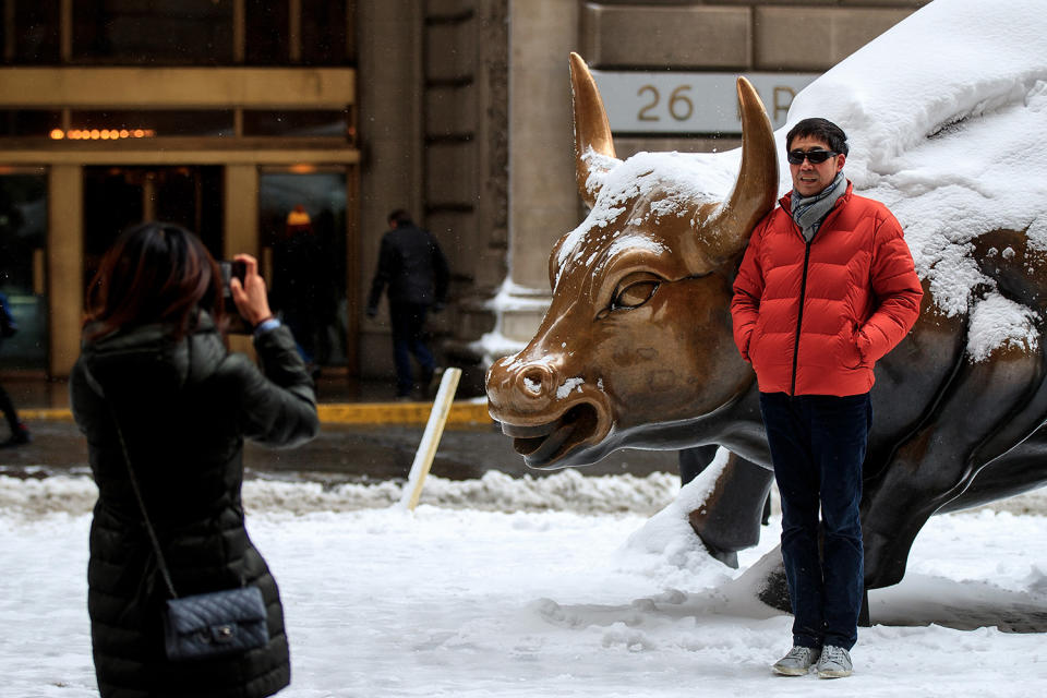 <p>A man poses next to the snow-covered Charging Bull sculpture in the Financial District, Feb. 9, 2017, in New York. (Photo: Drew Angerer/Getty Images) </p>