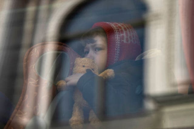 A child who fled the war in Ukraine waits in a bus after arriving in Poland 