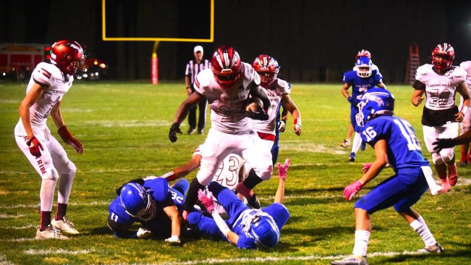 Chowchilla High School running back Dwayne Hemphill (22) runs over a couple of Caruthers defenders during the Tribe’s 32-31 win on Friday, Oct. 20, 2023.