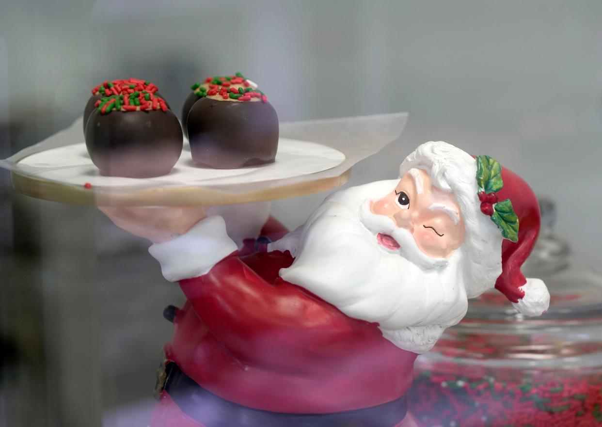 Dec.11, 2023; Columbus, Ohio, USA; 
Santa Claus holds a tray of holiday themed buckeyes at The Buckeye Lady store in Clintonville.