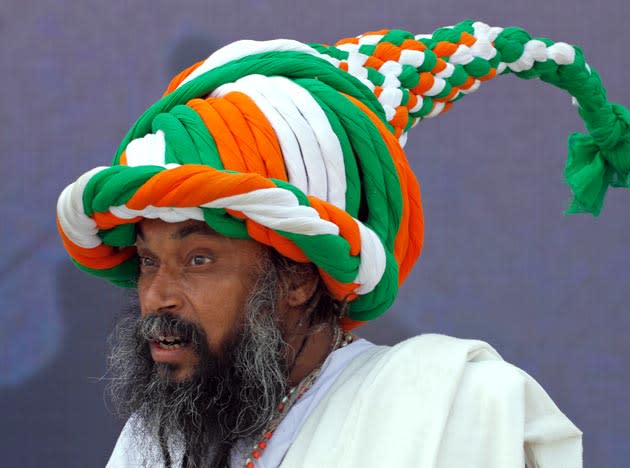 Baba Ramdas, 58, sports a turban in the colours of the Indian flag, that he claims weighs 3.5 kilograms and is made out of 81 meter long cloth at the annual cattle fair at Pushkar in Rajasthan state, India, Tuesday, Nov. 16, 2010. Pushkar is a popular Hindu pilgrimage spot that is also frequented by foreign tourists who come to the town for its annual cattle fair and camel races. The eight day long fair began Sunday. (AP Photo/Rajesh Kumar Singh)