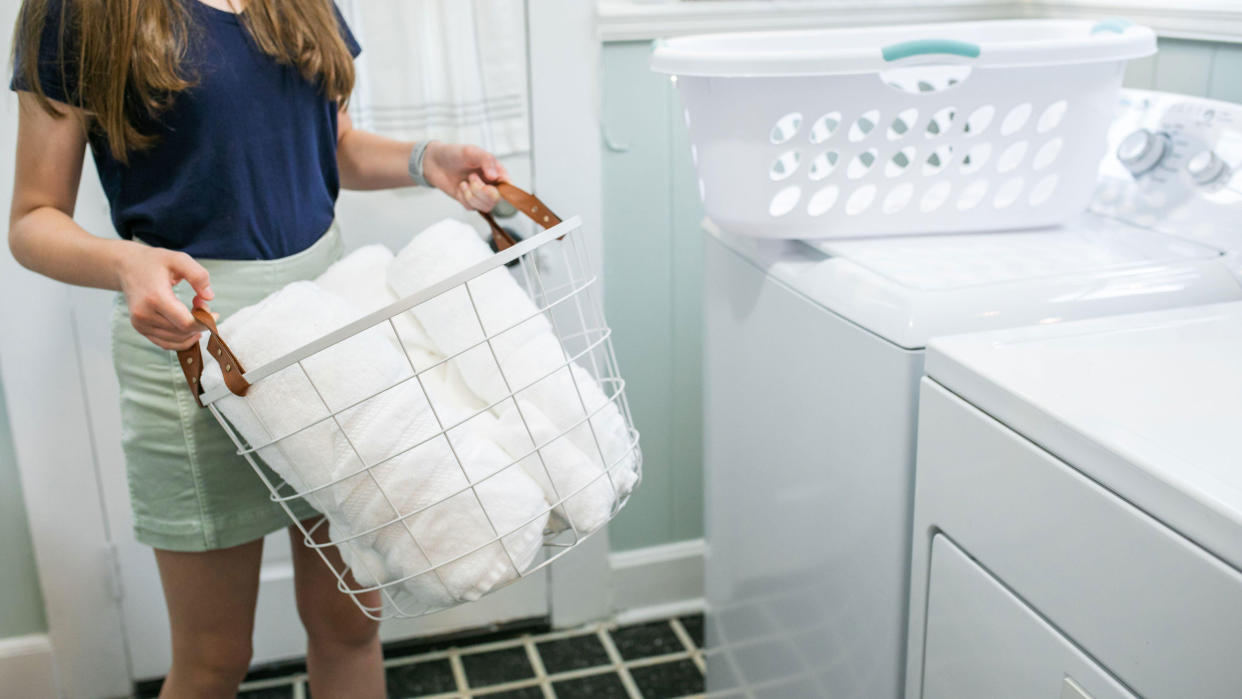  white towels in basket in laundry room 