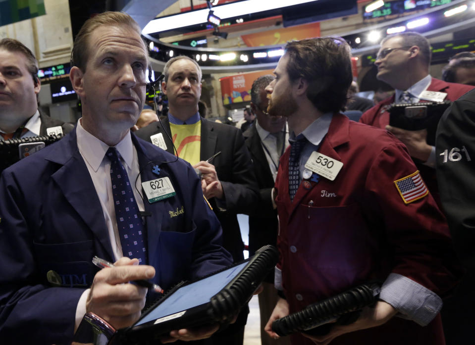 Michael Smyth, left, works with fellow traders on the floor of the New York Stock Exchange, Wednesday, March 26, 2014. The stock market opened higher Wednesday after a strong report on American manufacturing. The maker of the hit game "Candy Crush Saga" flopped in its market debut.(AP Photo/Richard Drew)