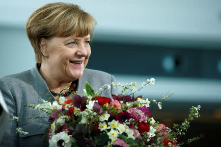 Chancellor Angela Merkel receives Valentine's Day flowers from the Central Gardening Association at the Chancellery in Berlin, Germany, February 9, 2018. REUTERS/Axel Schmidt