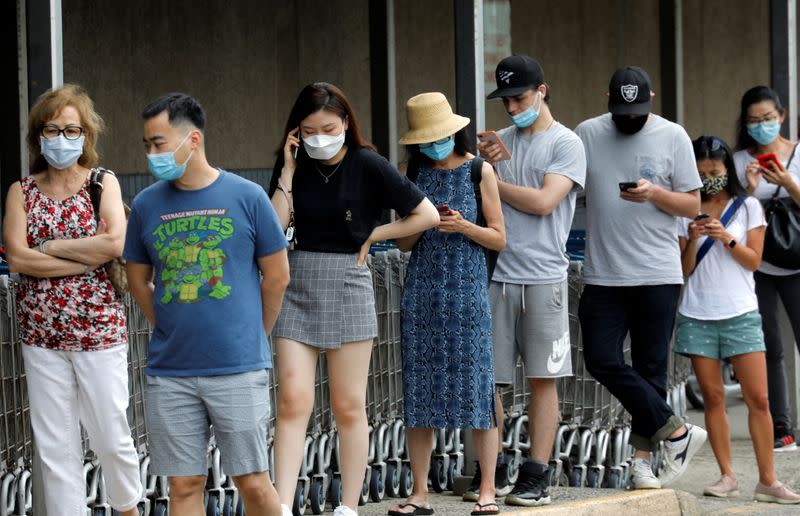 People wear protective face masks outside at a shopping plaza in Edgewater, New Jersey