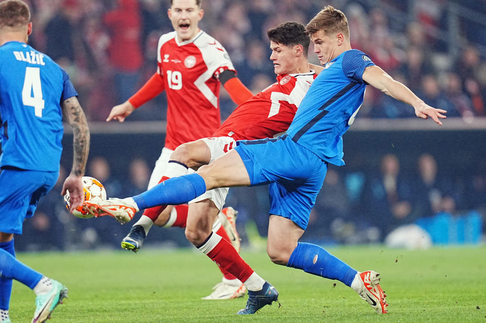 Christian Noregaard, de Dinamarca, disputa un balón con Jaka Bijol, de Eslovenia, en un cotejo de la eliminatoria a la Eurocopa, el viernes 17 de noviembre de 2023, en Copenhague (Liselotte Sabroe/Ritzau Scanpix via AP)