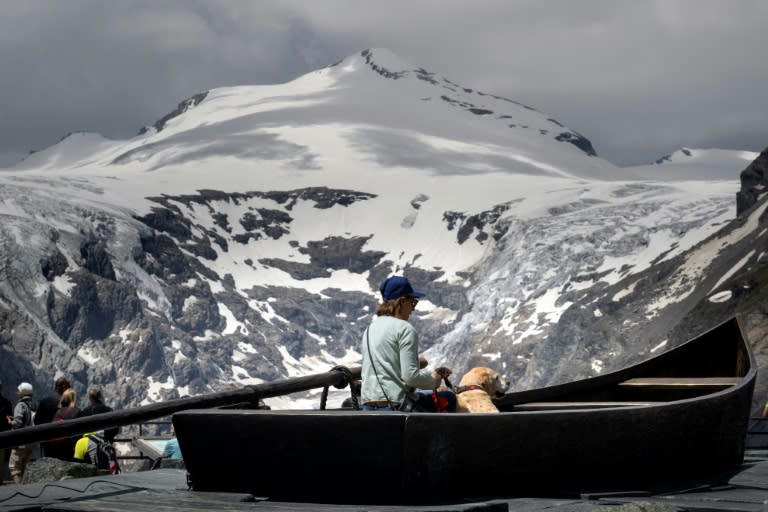 Un touriste regarde la fonte du glacier Pasterze depuis le point de vue Kaiser-Franz-Josefs-Hoehe dans la haute route alpine du Grossglockner, le 26 juin 2023 (JOE KLAMAR)