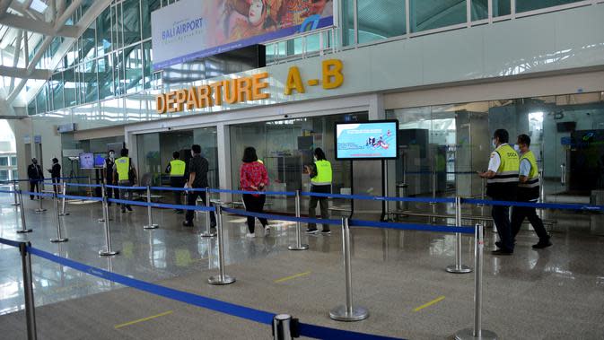 Petugas bandara berjalan di area keberangkatan internasional di bandara Ngurah Rai di Tuban dekat Denpasar di pulau resor Bali (5/10/2021).  Bandara Ngurah Rai akan kembali dibukan pada 14 Oktober untuk beberapa pelancong internasional. (AFP/Sony Tumbelaka)