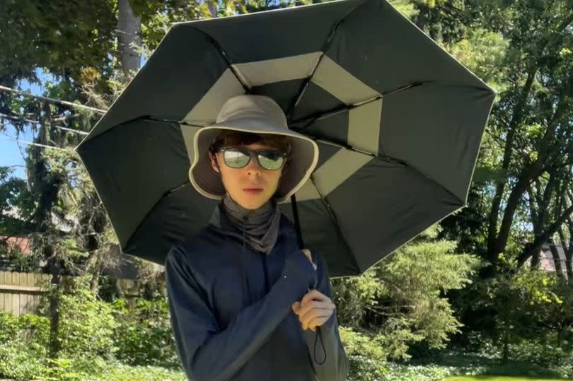 Brandon outside with a sun umbrella