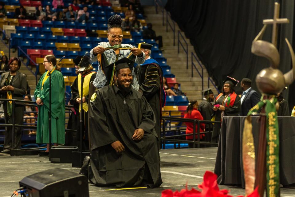 JaCarious Coleman, who graduated with a Bachelor of Science in physical education and health education, is hooded by his mother on the graduation stage on Saturday, Dec. 10, 2022.
