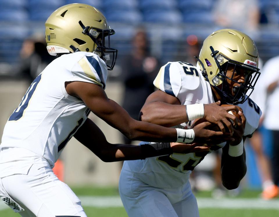 Hoban’s Tylan Boykin hands the ball to Caleb Jones in the first quarter Saturday against Frederick Douglass at Tom Benson Hall of Fame Stadium.