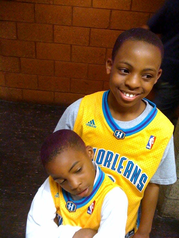 Shawn Preston Jr. stands behind his brother Shazz Preston as the St. James, Louisiana, natives sport New Orleans Hornets jerseys.