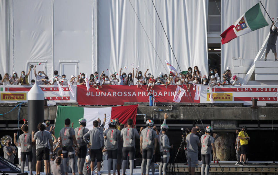 Supporters of Italy's Luna Rossa team wave as they celebrate after defeating Britain's INEOS Team UK in race eight of the Prada Cup on Auckland's Waitemata Harbour, New Zealand, Sunday, Feb. 21, 2021. Italian challenger Luna Rossa Prada Pirelli will race defender Emirates Team New Zealand in the 36th match for the America's Cup after beating Britain's Ineos Team UK in two races Sunday to seal a 7-1 win in the best-of-13 race challengers series final. (Alex Burton/NZ Herald via AP)