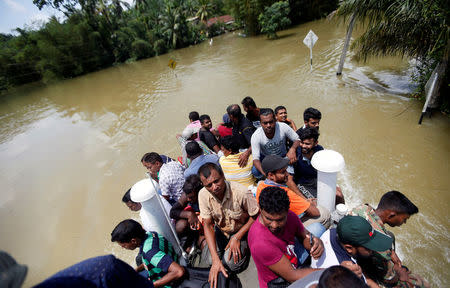 People are transported on top of an armoured personnel carrier on a flooded road during a rescue mission in Bulathsinhala village, in Kalutara, Sri Lanka May 27, 2017. REUTERS/Dinuka Liyanawatte