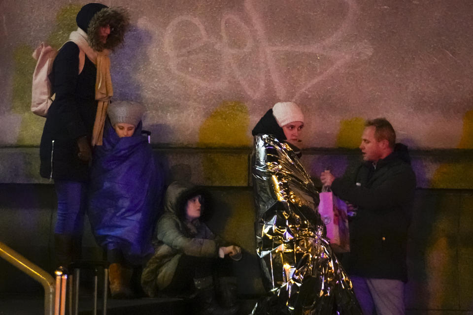 People wait near the building of Philosophical Faculty of Charles University in downtown Prague, Czech Republic, Thursday, Dec. 21, 2023. A mass shooting in downtown Prague killed several people and injured others, and the person who opened fire also is dead, Czech police and the city's rescue service said Thursday. (AP Photo/Petr David Josek)
