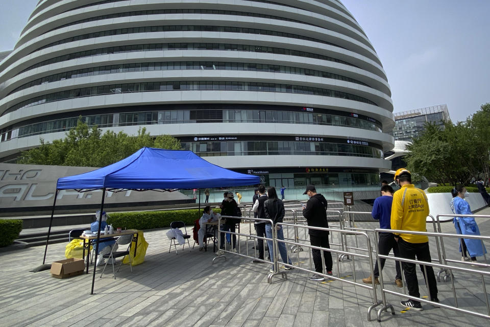 People line up for COVID-19 tests at a testing site in an office complex in Beijing, Friday, April 29, 2022. While the U.S. and other countries are dropping restrictions and opening - with some health officials even saying the worst is over - China is keeping its international borders largely shut and closing off entire cities with millions of residents to all but essential travel. For the Chinese capital, however, the political stakes are heightened as the ruling party moves toward a crucial national congress. (AP Photo/Mark Schiefelbein)