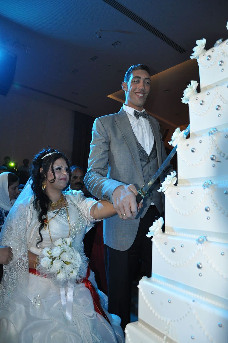 The world's tallest man, Sultan Kosen, and his new wife, cut their wedding cake. Photo: AAP.