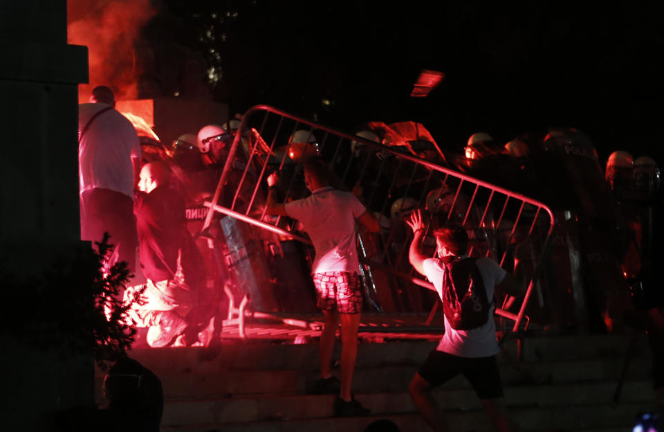 Manifestantes chocan con la policía antimotines en la escalinata del parlamento durante una manifestación el viernes 10 de julio de 2020, en Belgrado, Serbia. (AP Foto/Darko Vojinovic)