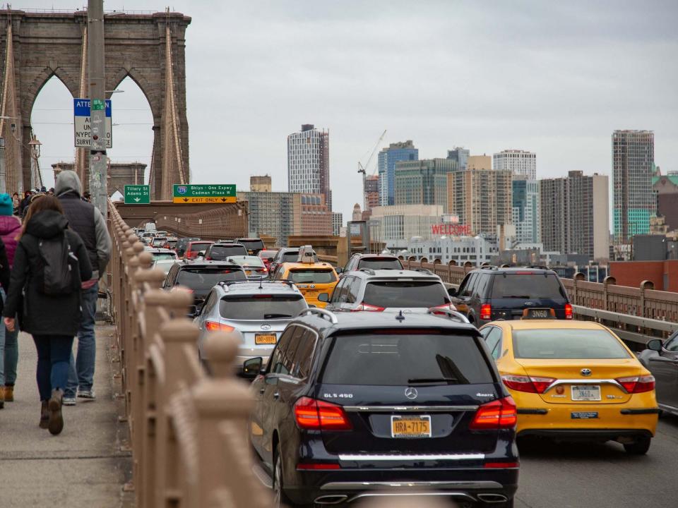 Cars and people crossing the Brooklyn Bridge