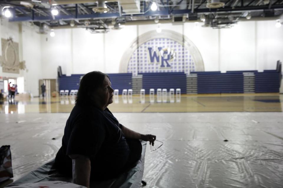 Mary Lewis, an evacuee from the Tick fire, sits on a cot at a shelter inside the West Ranch high school gym in Santa Clarita.