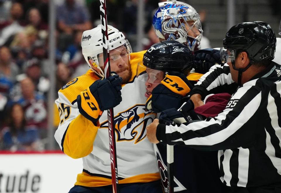 Apr 28, 2022; Denver, Colorado, USA; NHL linesman Jonny Murray (95) breaks up a fight between Nashville Predators right wing Mathieu Olivier (25) and Colorado Avalanche right wing Logan O'Connor (25) in the first period at Ball Arena. Mandatory Credit: Ron Chenoy-USA TODAY Sports