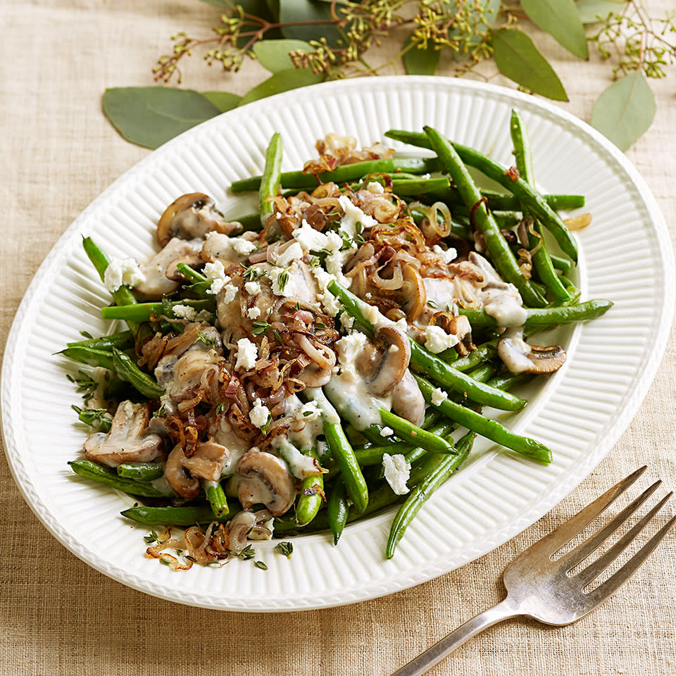 <p>A much healthier take on the old-fashioned green bean casserole, this version thankfully skips the canned soup and fried onions! Fresh green beans are cooked until crisp-tender and topped with a garlicky-thyme mushroom sauce, shallots and crumbled chèvre. <a href="https://www.eatingwell.com/recipe/266705/green-beans-with-creamy-mushroom-sauce/" rel="nofollow noopener" target="_blank" data-ylk="slk:View Recipe" class="link ">View Recipe</a></p>