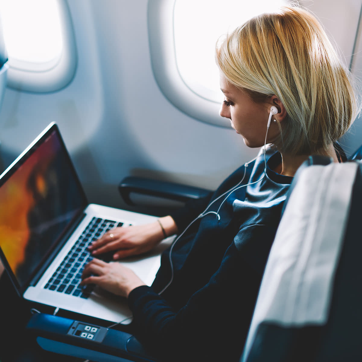 woman-using-macbook-on-airplane