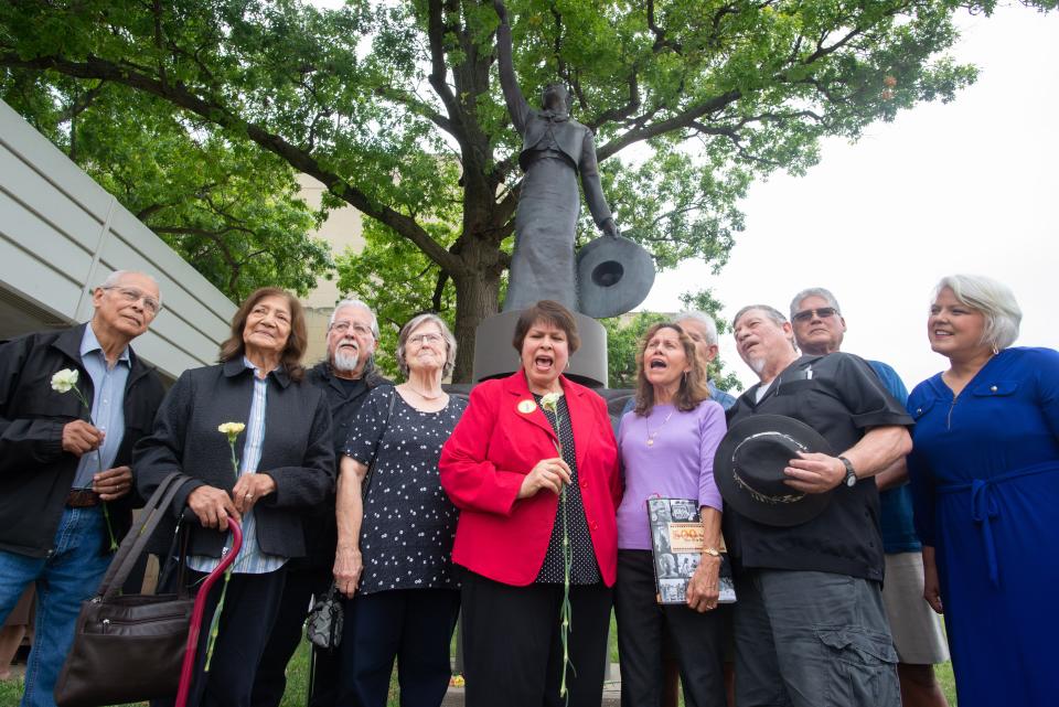 The surviving members of Mariachi Estrella de Topeka and family from the four deceased musicians sing in front of the statue honoring the group at the Topeka Performing Arts Center on July 16, 2021, 40 years after the tragedy in Kansas City, Missouri.