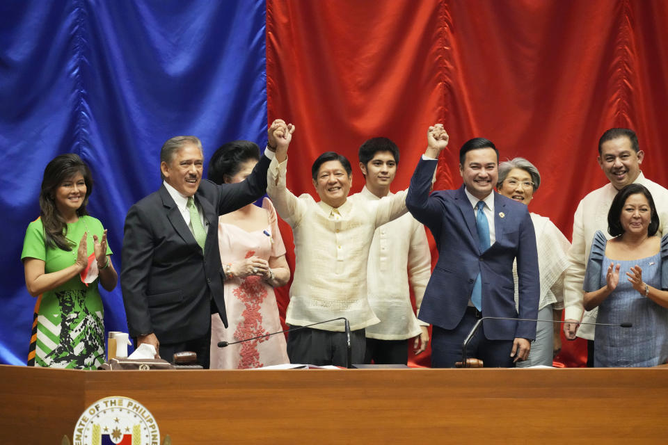 Philippines President-elect Ferdinand "Bongbong" Marcos Jr., center, raises hands with Senate President Miguel Zubiri, left, and House speaker Lord Allan Velasco after his proclamation by the National Board of Canvassers on Wednesday May 25, 2022 at the House of Representatives, Quezon City, Philippines. (AP Photo/Aaron Favila)