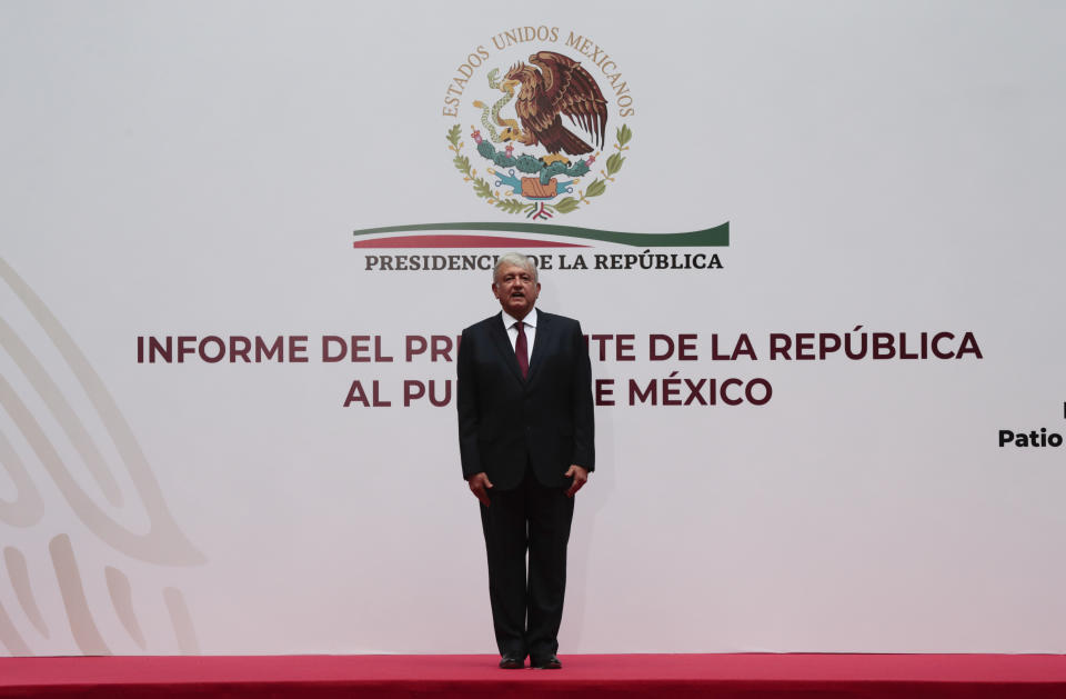 Mexican President Andres Manuel Lopez Obrador stands at attention at the National Palace in Mexico City, Sunday, April 5, 2020. López Obrador spoke to the nation about his economic recovery plan. Mexico's government has broadened its shutdown of "non essential activities," and prohibited gatherings of more than 50 people as a way to help slow down the spread of COVID-19. The one-month emergency measures will be in effect from March 30 to April 30. (AP Photo/Eduardo Verdugo)