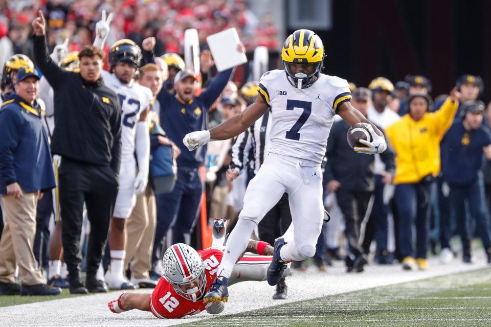 Michigan running back Donovan Edwards (7) runs past Ohio State safety Lathan Ransom  during the second half Nov. 26, 2022 at Ohio Stadium in Columbus.